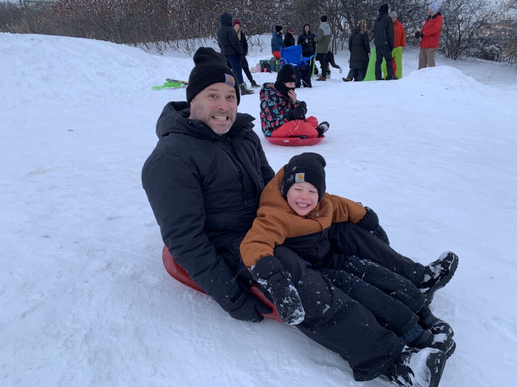 Jon Willing and his son Miles prepare to zip down the hill at Carlington Park in Ottawa. Photo credit Nicole Willing