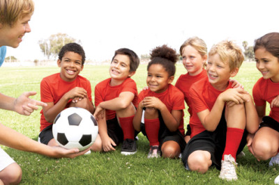 Young Boys And Girls In Football Team With Coach